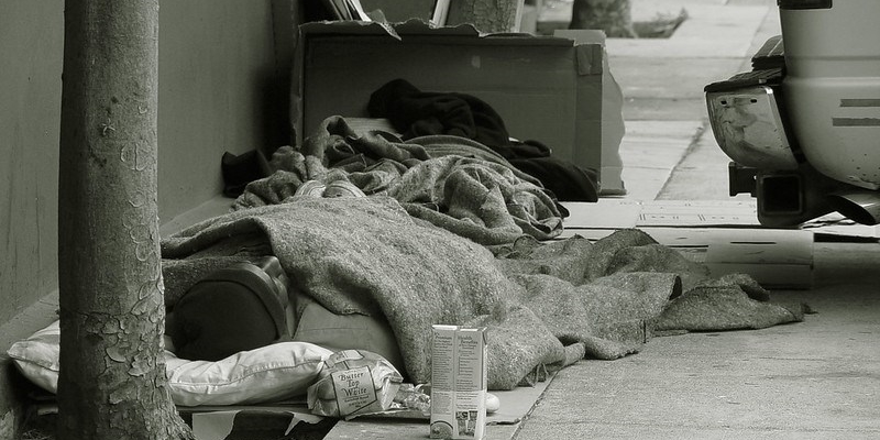 Senza dimora dorme su un marciapiede